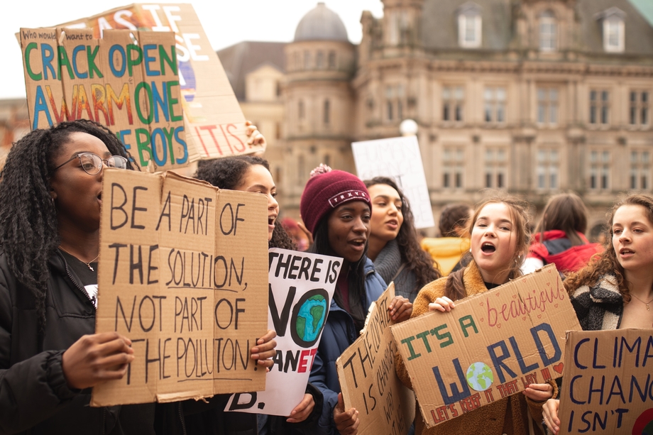 Women protesting against climate change with cardboard signs