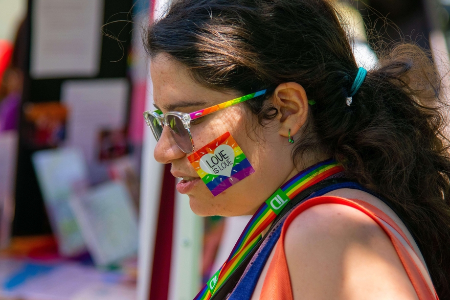 Person with face paint of a rainbow flag and the text "Love is Love"